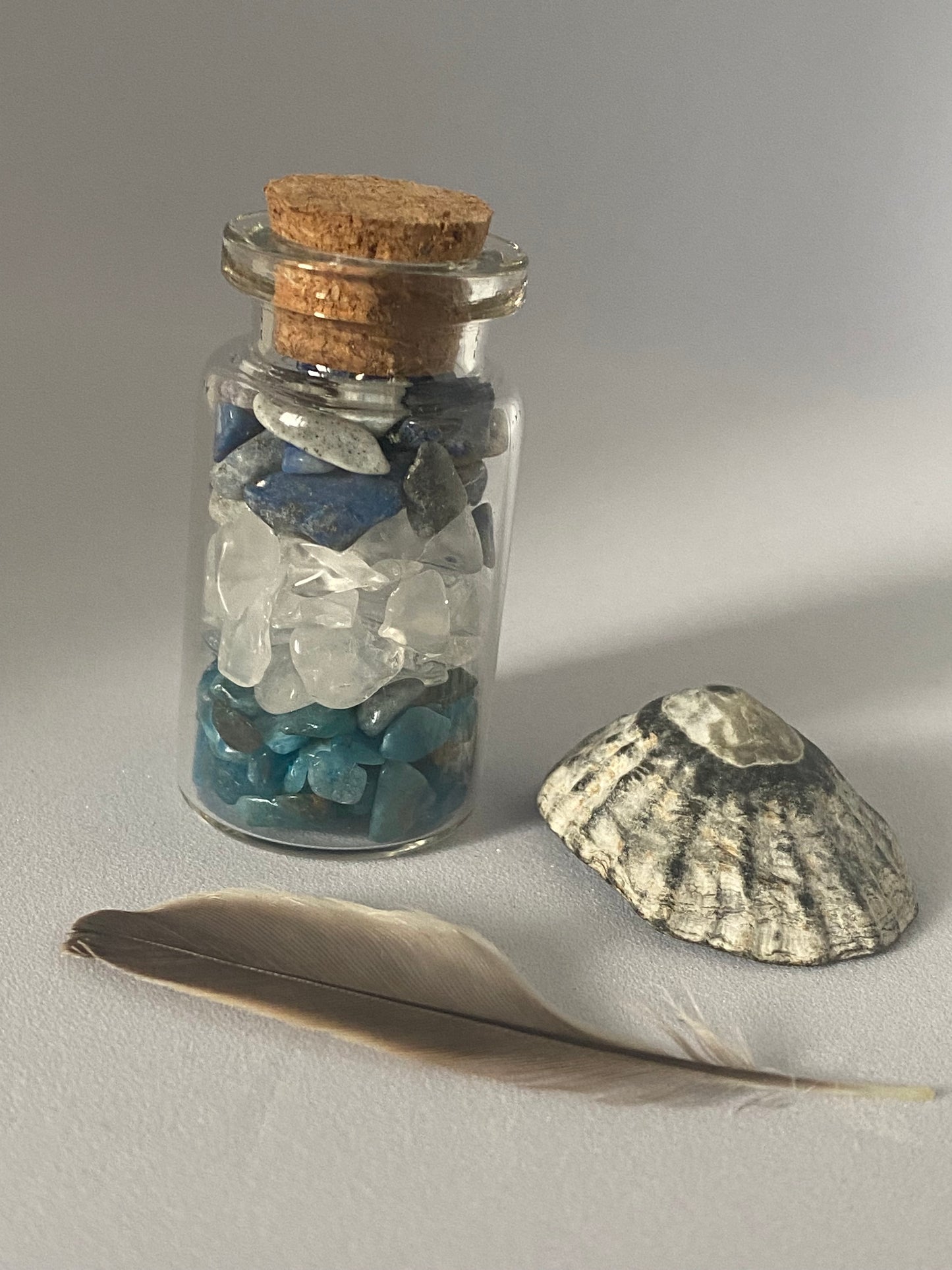 fiole d'intention ou spelljar, contenant des chips de pierre naturelle favorisant la communication, le lapis lazuli, l'apatite bleue et le cristal de roche